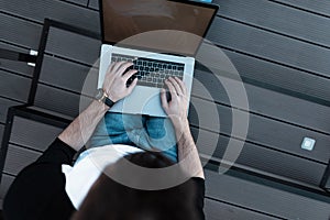 Young man freelancer working on a modern laptop. Top view of a young busy worker. Remote work. Work time.