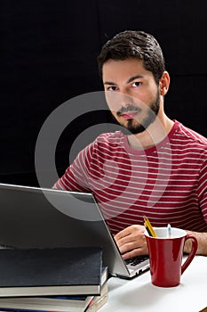 Young man in front of laptop hands over keyboard