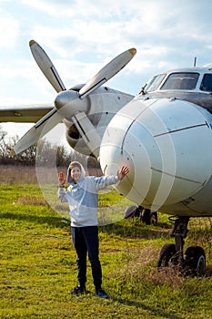 A young man in front of an old abandoned Soviet plane.