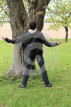 Young man in front of tree