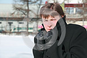 Young man froze in winter and hides head in collar