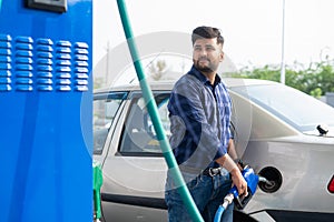 young man fueling car at petrol or gas filling station - concept of transportation, transportation and self-service.