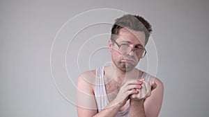 Young man in funny glasses counting something on fingers