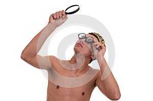 Young man with funny glasses looking through magnifyin
