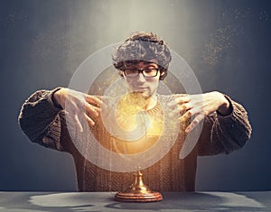 Young man gazing at the glowing crystal ball. photo