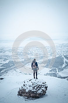 Young man gazing at the horizon surrounded by snow