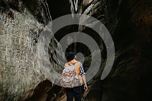 A young man geologist explores a mountain cave, travel concept