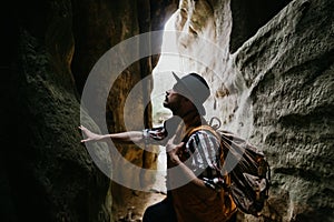 A young man geologist explores a mountain cave, travel concept