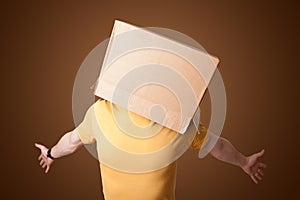 Young man gesturing with a cardboard box on his head