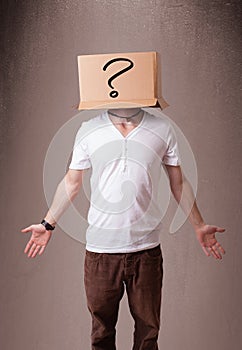 Young man gesturing with a cardboard box on his head with question mark