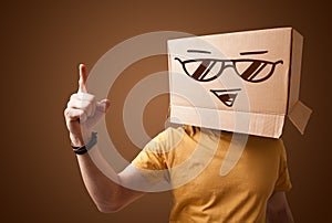 Young man gesturing with a cardboard box on his head with smiley