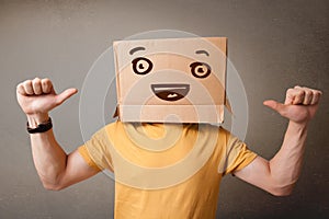 Young man gesturing with a cardboard box on his head with smiley