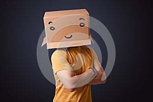 Young man gesturing with a cardboard box on his head with smiley