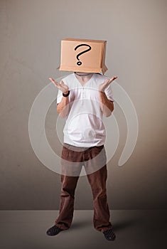 Young man gesturingwith a cardboard box on hishead