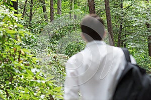 Young man is getting away from urban area to go hicking in the forest