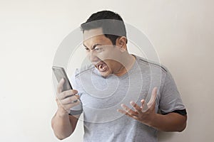 Young Man Getting Bad News on Phone, Shocked and Angry