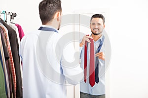 Young man getting dressed in front of a mirror