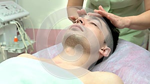 Young man getting face massaged.