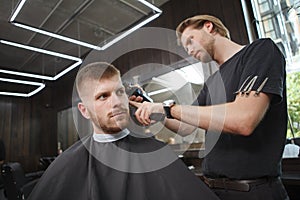 Young man getting new haircut at barbershop