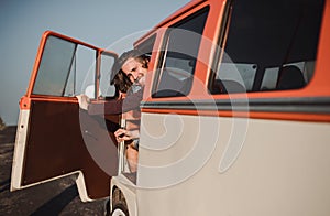 A young man getting out of a car on a roadtrip through countryside. Copy space.