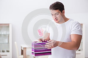 The young man with gift bag at home preparing suprise for wife