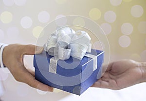 young man give a gift in a box,holding blue Gift box with bow over holiday