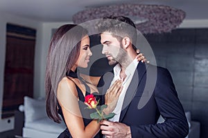 Young man give rose to lover indoor