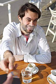 Young man giving credit card for payment at restaurant