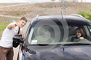 Young man giving directions to a woman driver