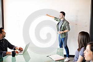 Young man giving presentation to colleagues