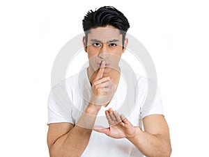 young man giving Shhhh quiet, silence, secret gesture isolated on white background