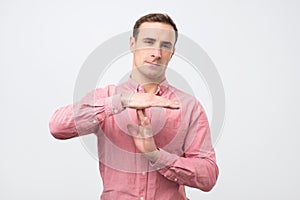 Young man giving showing time out hands gesture