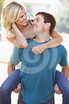 Young Man Giving Woman Piggyback Outdoors