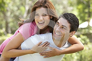 Young Man Giving Woman Piggyback Outdoors