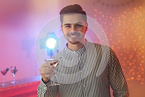 Young man with glass of martini cocktail