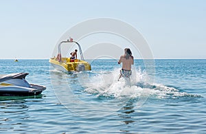 Young man glides on water skiing on the waves on the sea, ocean. Healthy lifestyle. Positive human emotions, feelings,