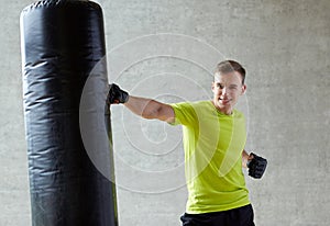 Young man in gloves boxing with punching bag