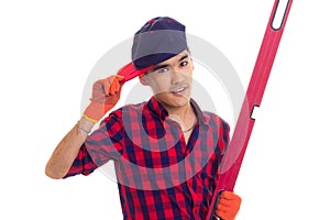 Young man in gloves and snapback holding level