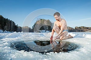 Young man going to swim in an ice hole