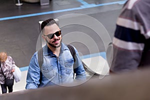 Young man going up in escalator inside subway station. Concept o