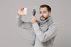Young man in gray sweater, scarf isolated on grey background. Healthy lifestyle, ill sick disease treatment, cold season