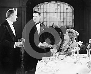 Young man greeting a couple at the dinner table