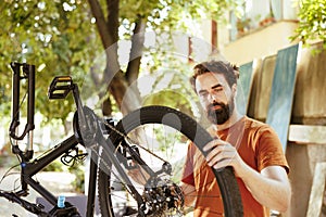 Young man gripping damaged bicycle wheel