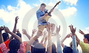 Young Man with a Guitar Performing on an Ecstatic Crowds photo