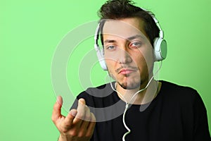 Young man or guy on a light green background. The emotion of perplexity on the face