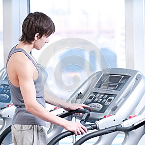 Young man at the gym exercising. Running