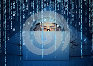 Man hacker working on a laptop on binary code background