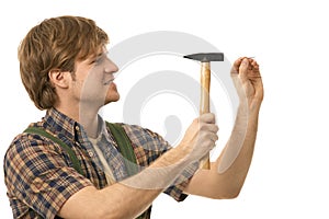 Young man hammering nail