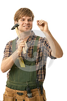 Young man hammering nail