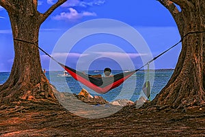 Young man hammock facing the sea